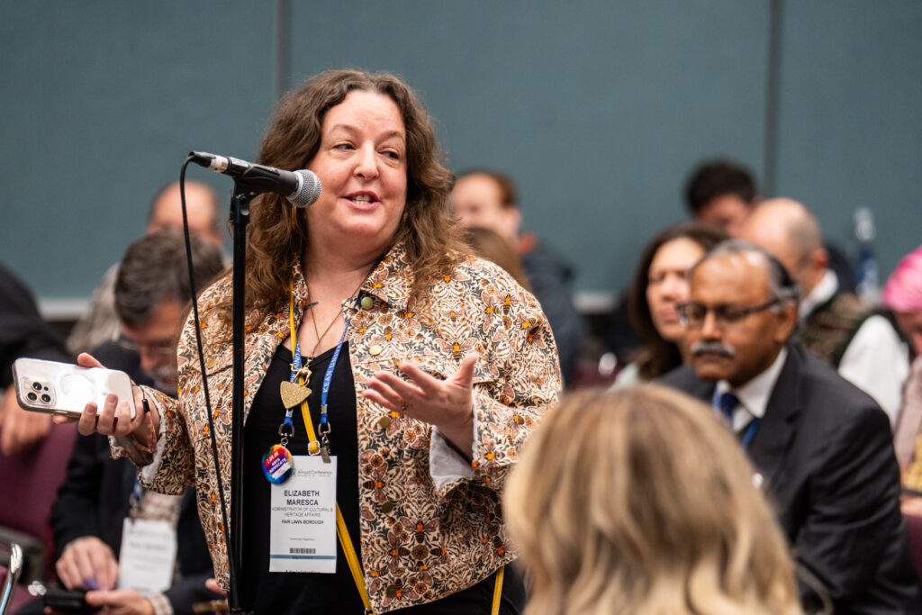 Woman in audience asking a question at microphone.